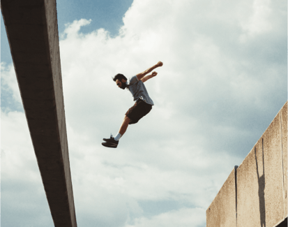 Man midair from doing a parkour jump, about to land