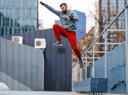 Man jumping and doing parkour in an urban setting.