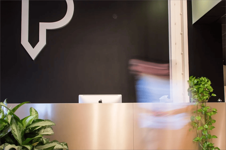 Person moving in front of a desk facing the large Parkour3 logo