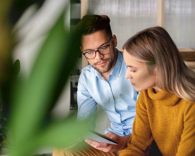 Two experts collaborate on a digital project in a professional setting.