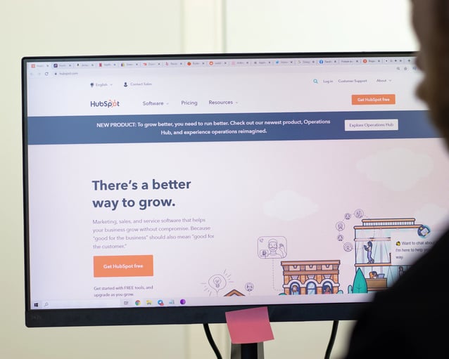 A computer screen displaying the HubSpot platform, presenting marketing software and a message about business growth.