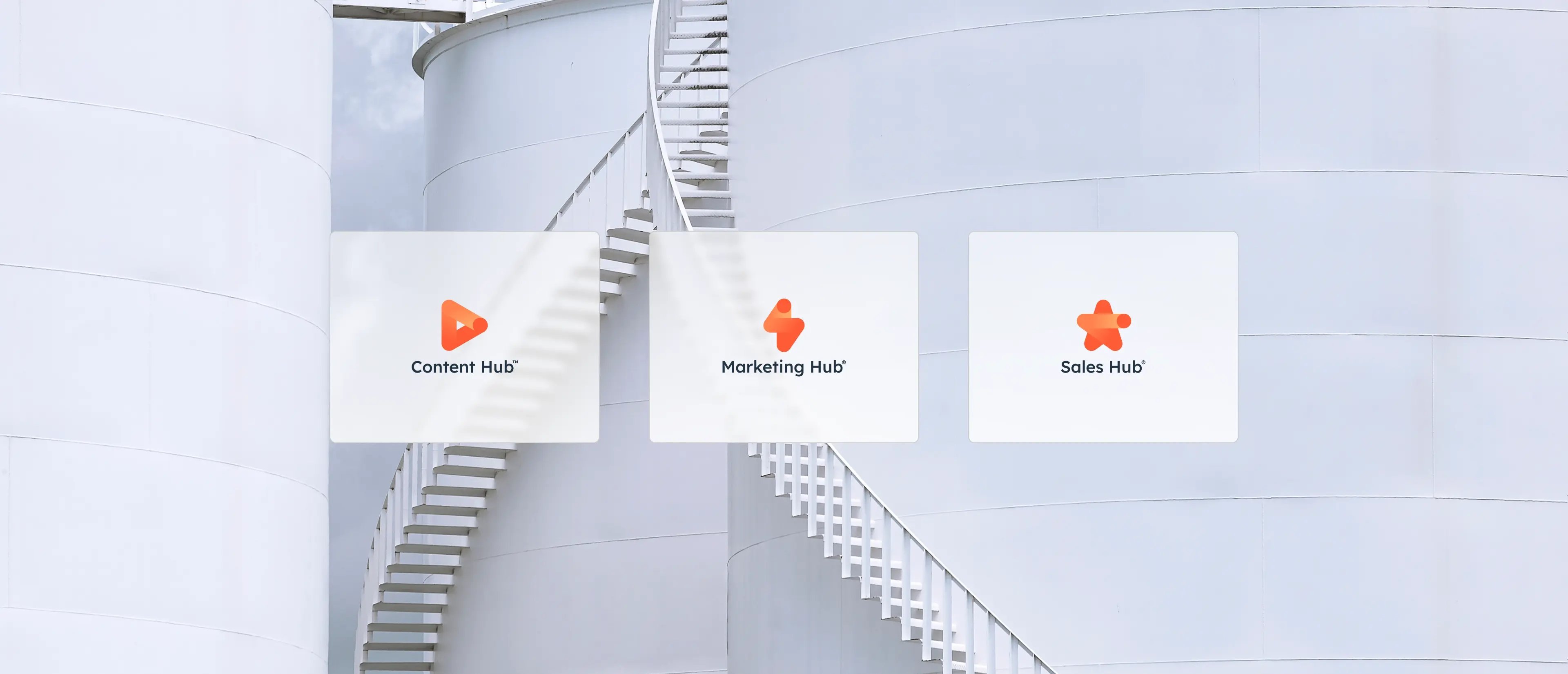Trois icônes de hub numérique - Content Hub, Marketing Hub, Sales Hub - superposées à une structure cylindrique blanche moderne avec un escalier en colimaçon.