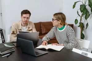 Deux collègues travaillant devant leurs ordinateurs.